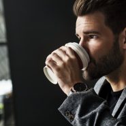 Side view of mna drinking hot coffee